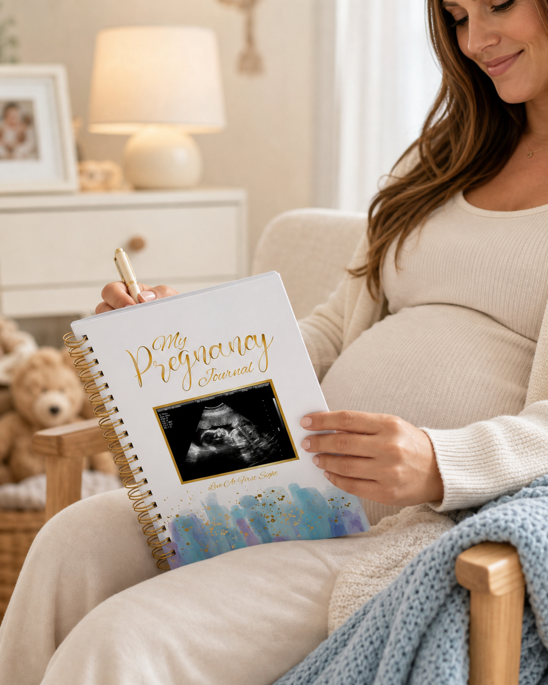 Expecting mom holding and writing in a TISAYN pregnancy journal